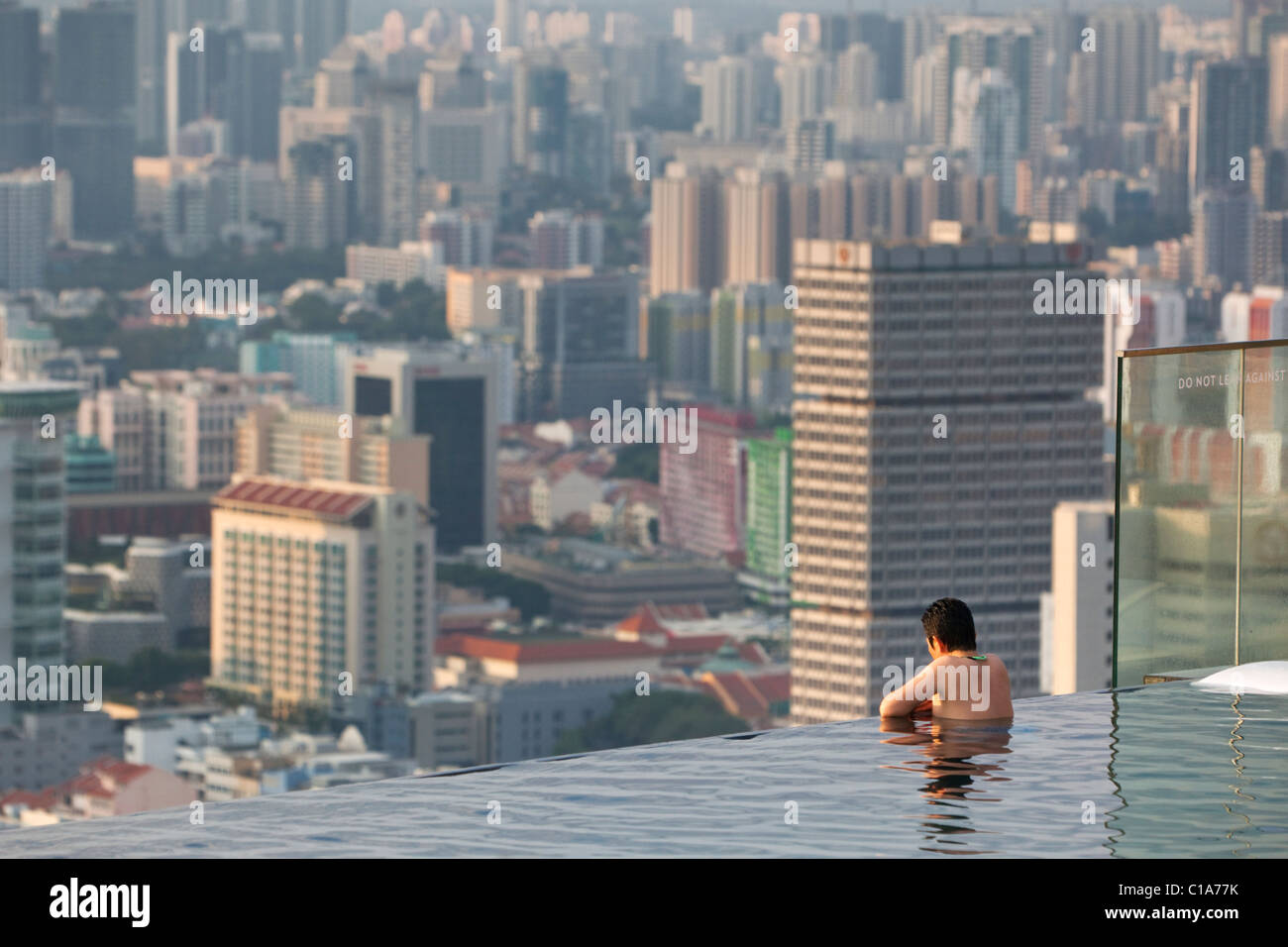 Nuotatore guardando fuori oltre a Singapore dalla Marina Bay Sands SkyPark piscina. Il Marina Bay, Singapore Foto Stock