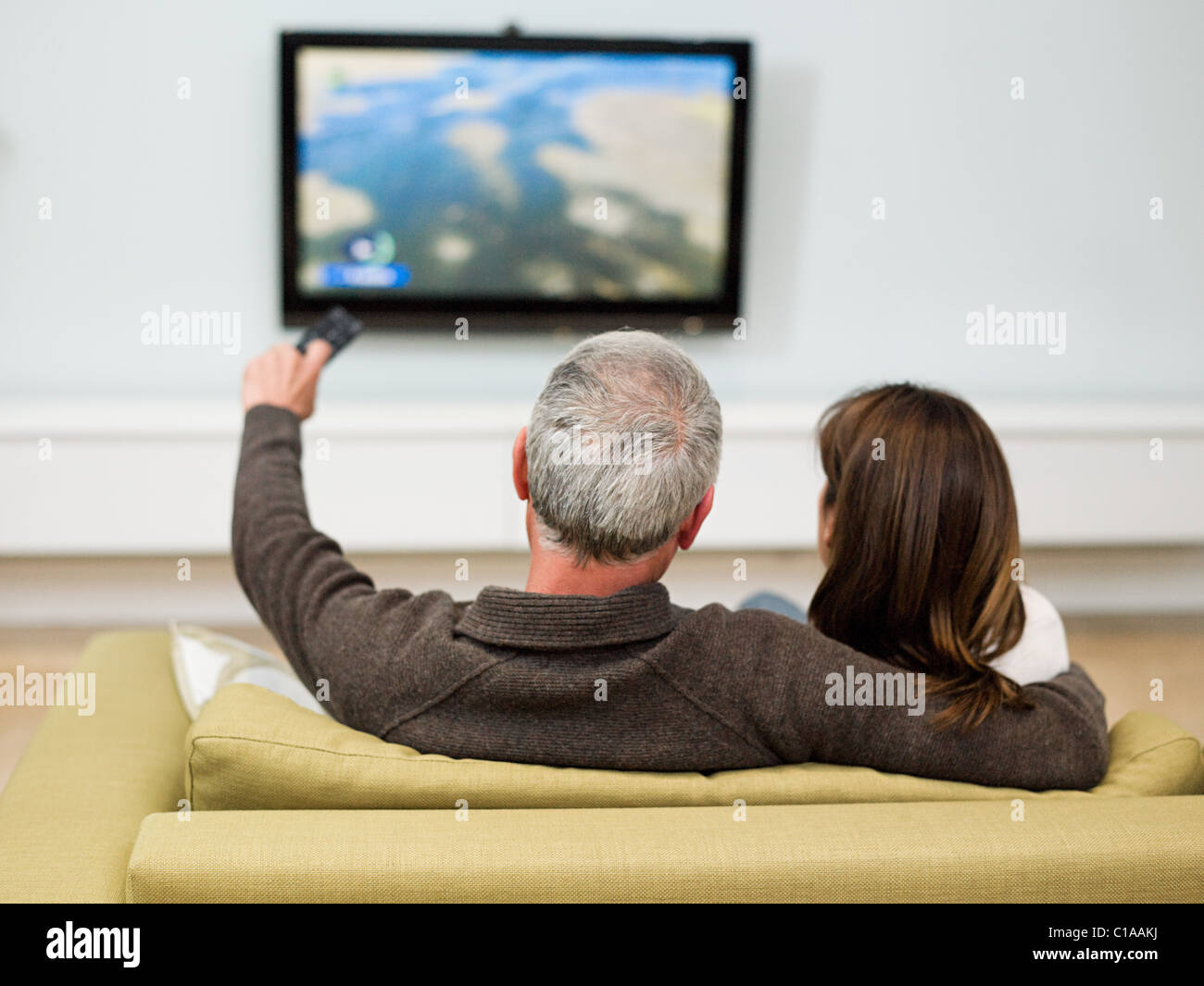 Coppia matura seduti sul divano a guardare la televisione Foto Stock