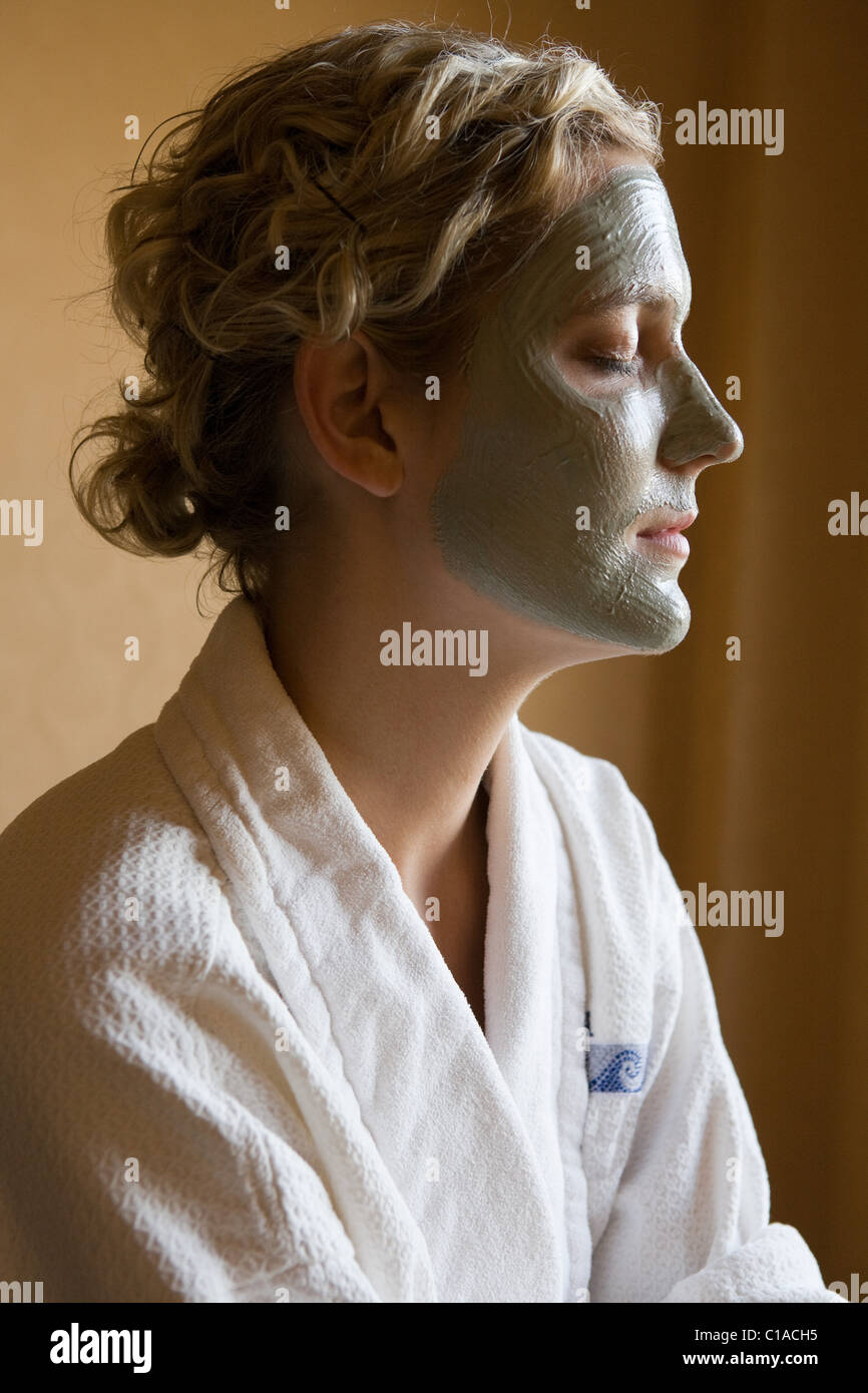 Giovane donna con maschera di fango sulla faccia Foto Stock