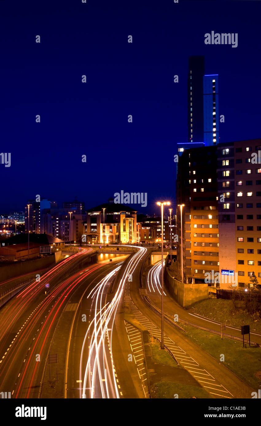 Semaforo sentieri dei veicoli che viaggiano troppo e dalla città di Leeds a notte Yorkshire Regno Unito Foto Stock