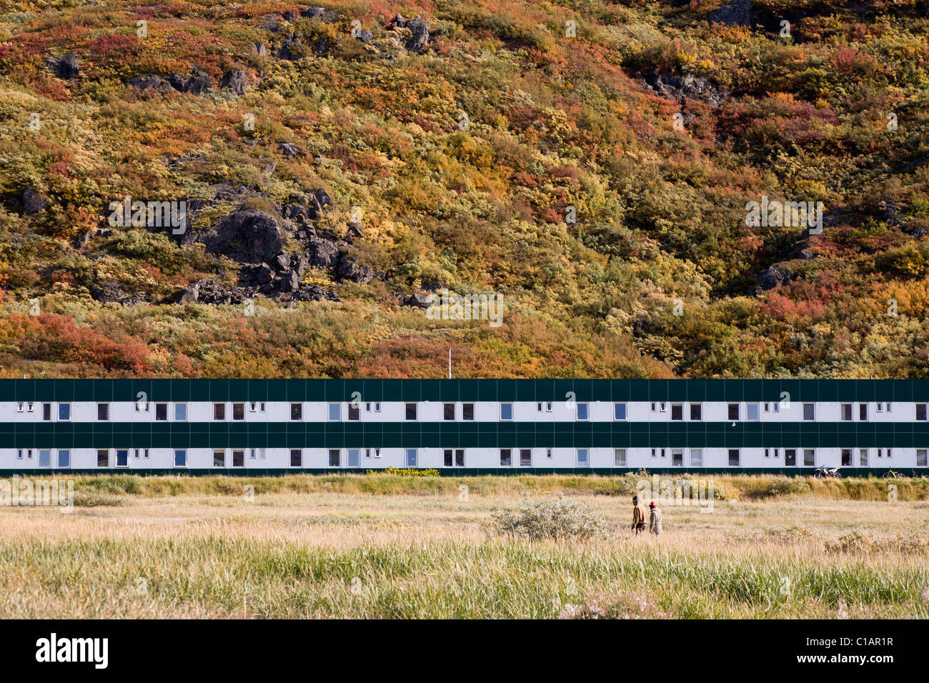 Le persone camminare davanti a un blocco di appartamenti. Narsarsuaq, Groenlandia meridionale Foto Stock