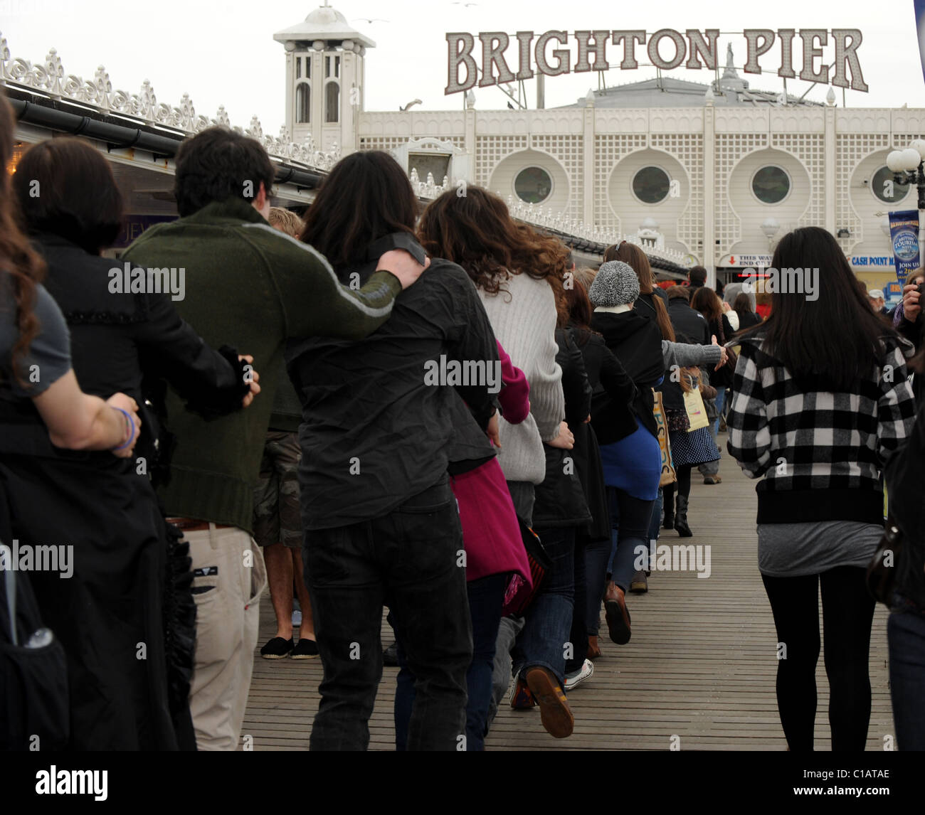 Le persone che hanno preso parte ad uno speciale Congathon intorno al molo di Brighton sperando per impostare un nuovo record del mondo e sollevare il pagamento in contanti per Macmillan Foto Stock