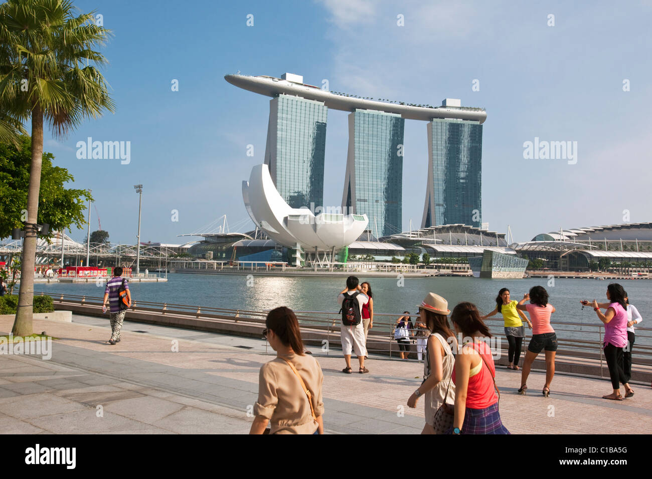 La gente camminare lungo la baia di Marina lungomare con il Marina Bay Sands in background. Il Marina Bay, Singapore Foto Stock