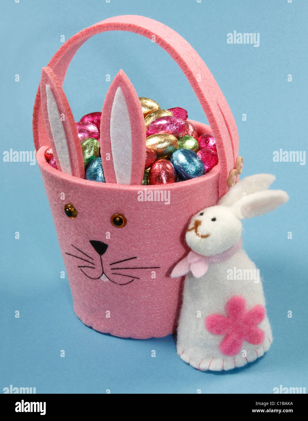 Rosa Cesto di Pasqua con uova di cioccolato e Bunny su sfondo blu. Foto Stock