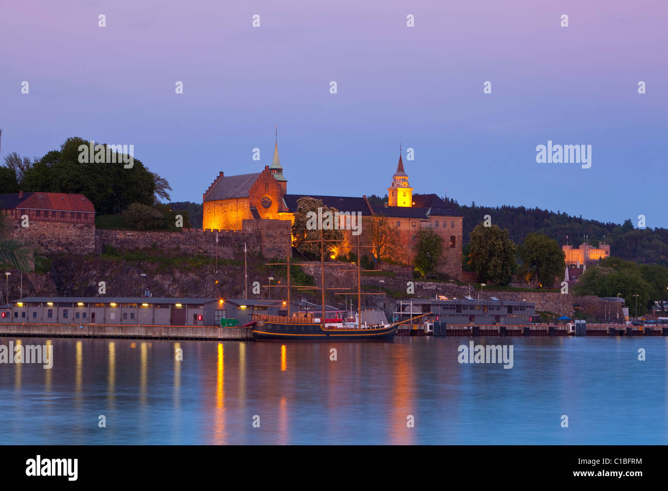 La Fortezza di Akershus & porto illuminato al crepuscolo, Oslo, Norvegia Foto Stock
