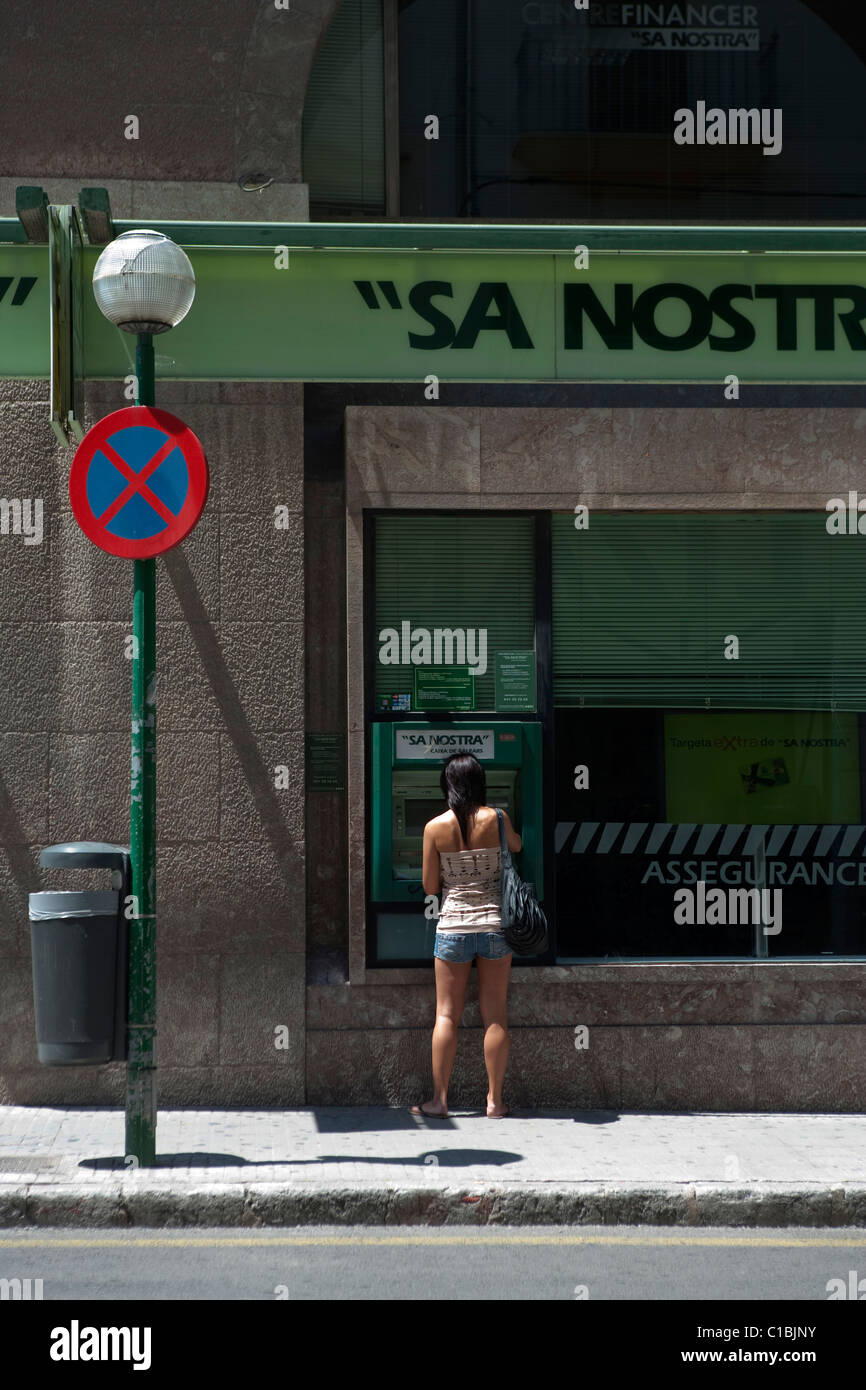 Donna che utilizza "ATM cash dispenser' 'Sun' nosta banca strada in Palma de Maiorca Spagna Foto Stock