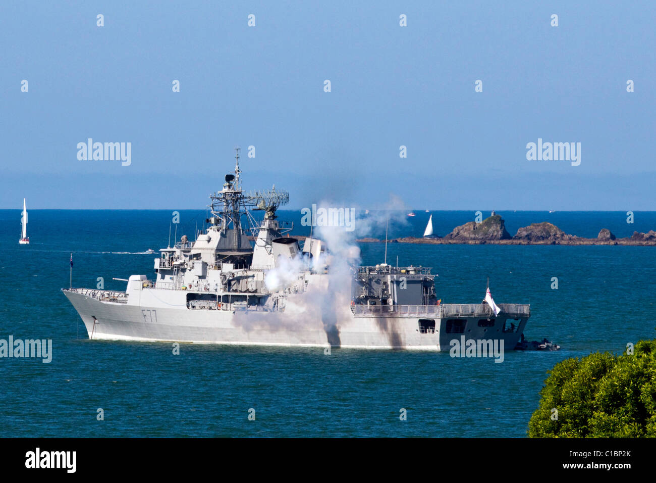 L'ombelico nave Te Kaha spara con una pistola salutate come il Royal New Zealand Navy eseguire una battitura retreat Tramonto Cerimonia Foto Stock