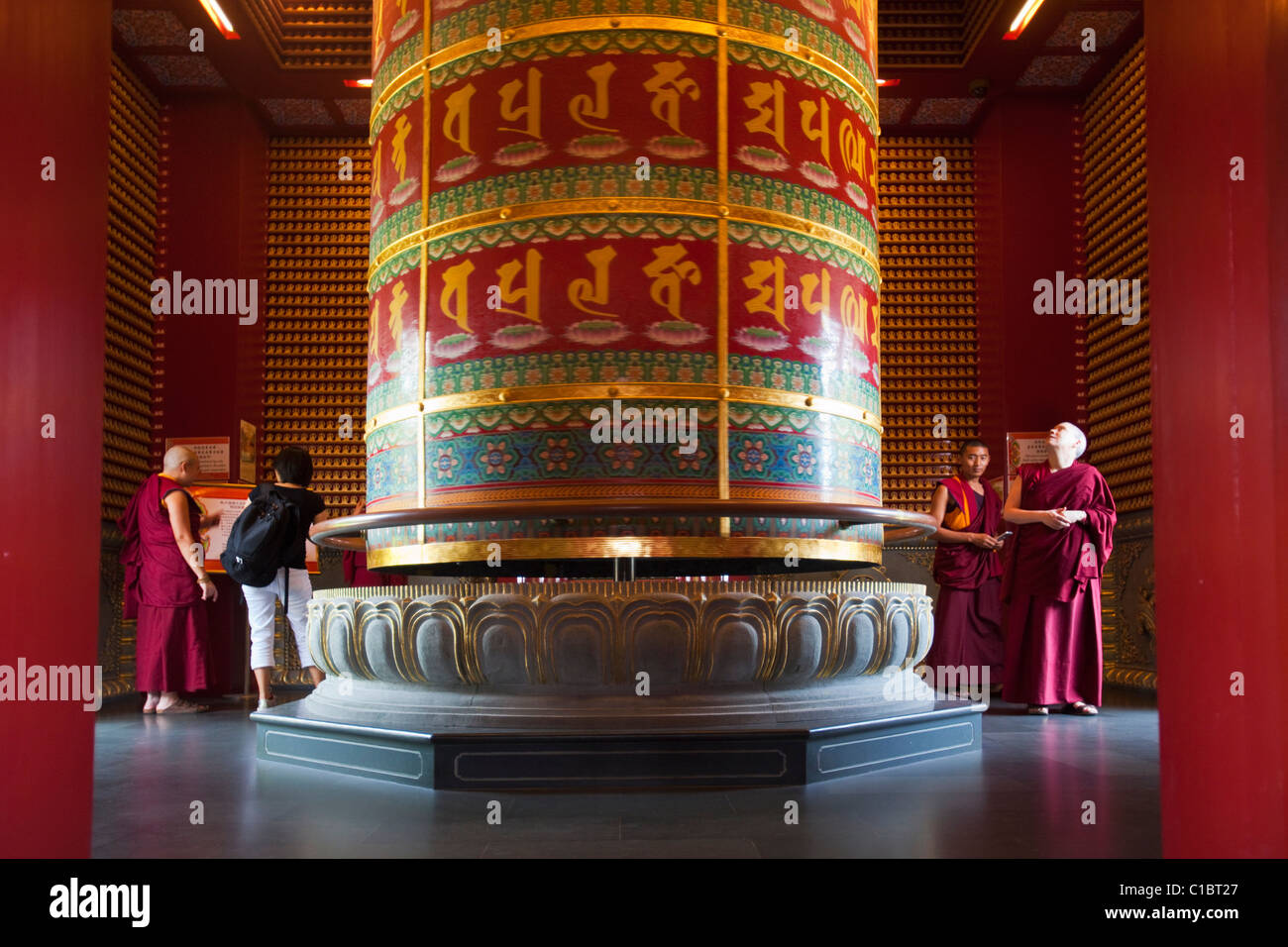 I monaci e le gigantesche ruote di preghiera in Diecimila Buddha Padiglione. Dente del Buddha reliquia del tempio e museo, Chinatown, Singapore Foto Stock