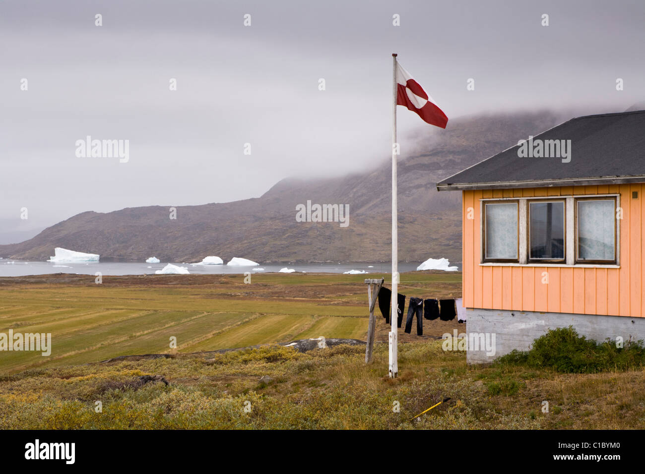 La bandiera groenlandese al di fuori di una casa a Narsaq, Groenlandia meridionale. Foto Stock