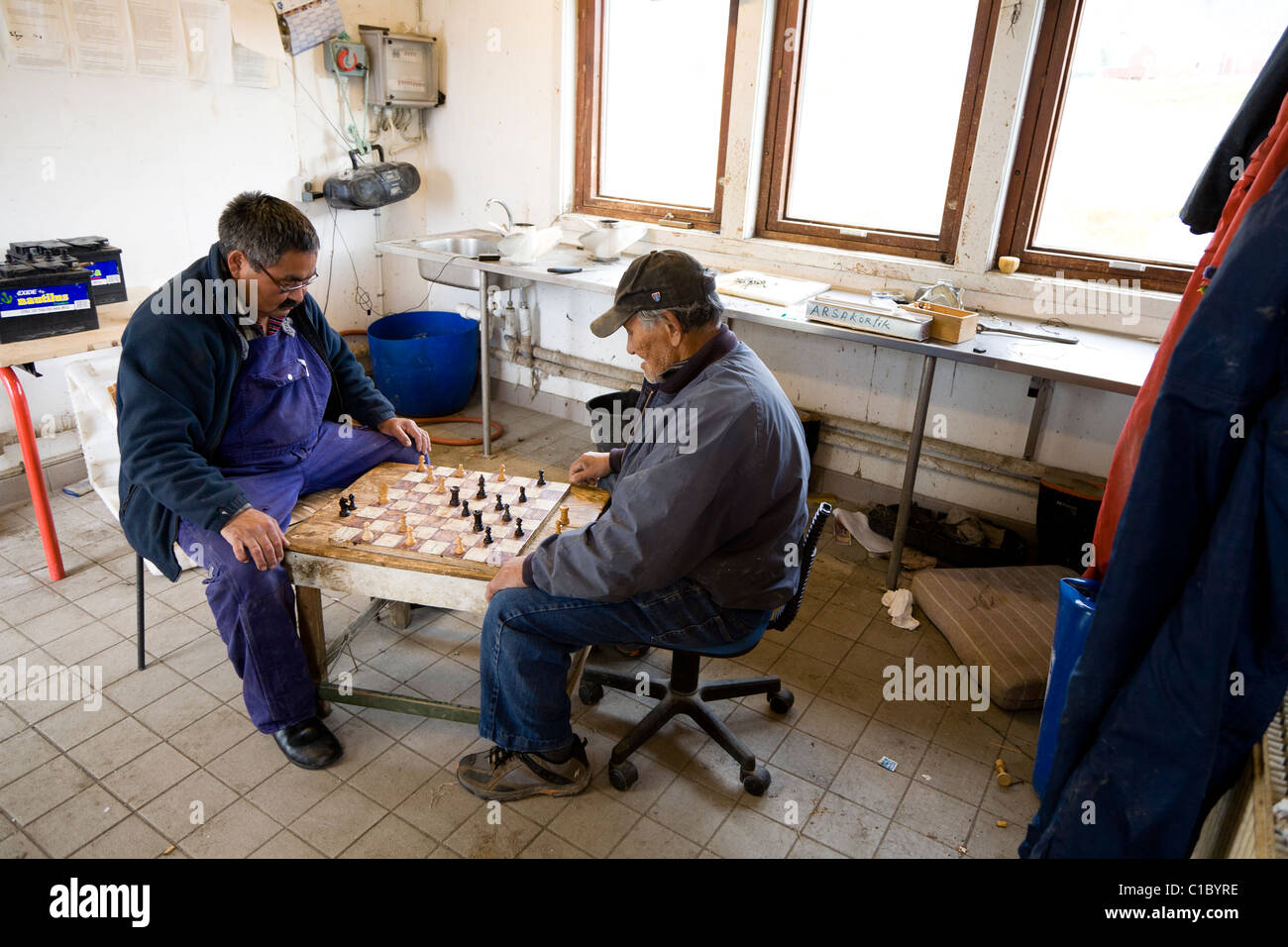 I pescatori a giocare "dama' gioco di bordo. Anche chiamato 'Draughts' gioco di bordo. Di pescatori di capanne, Narsaq, Groenlandia meridionale Foto Stock