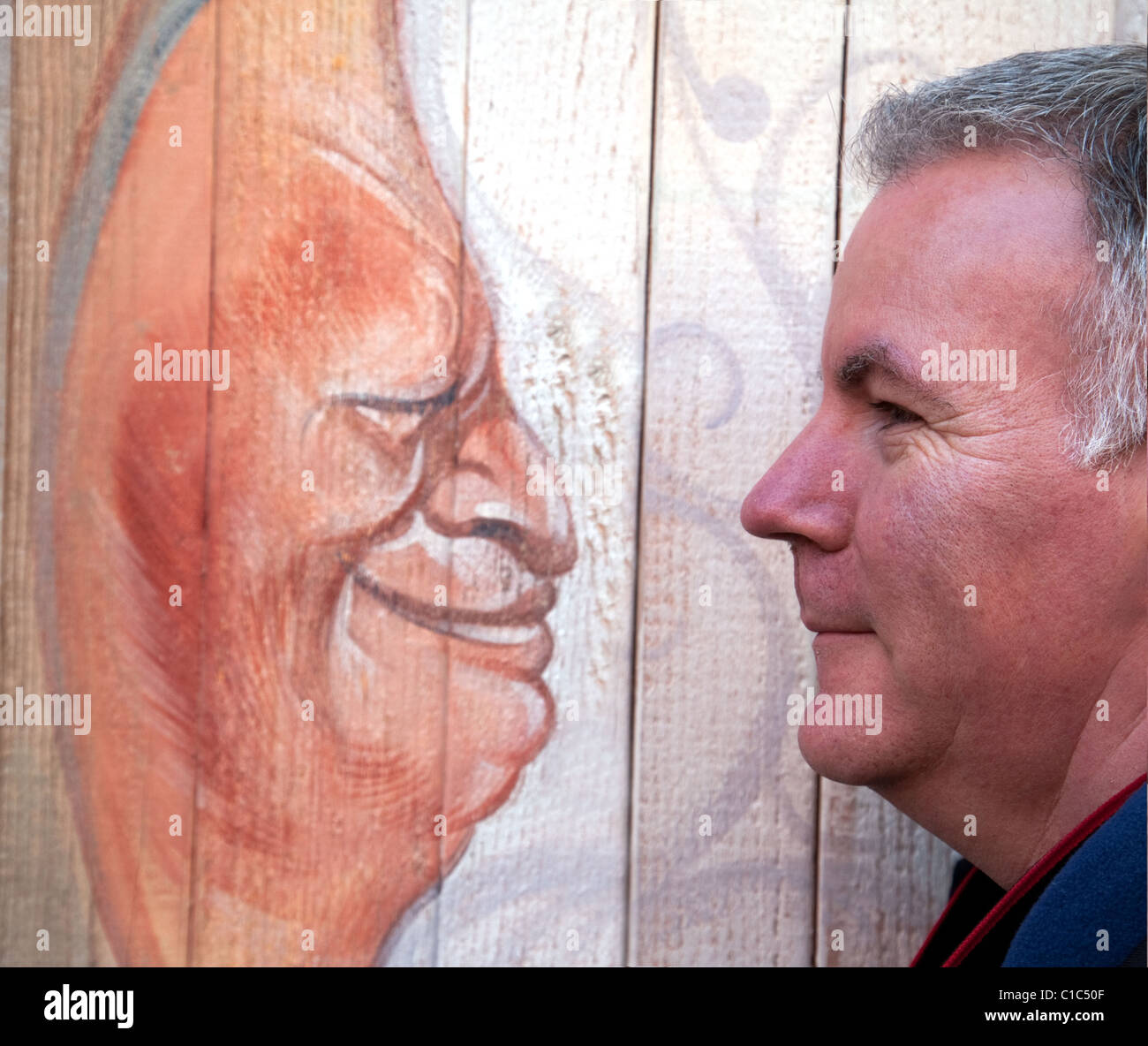Candide street photography, un uomo di fronte a un dipinto di un uomo, Venezia, Italia Foto Stock