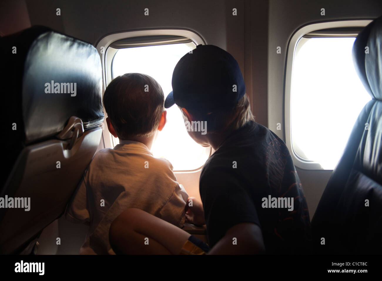 Due fratelli giocando su un aereo durante un lungo volo a visitare la loro famiglia a Seattle, WA. Foto Stock