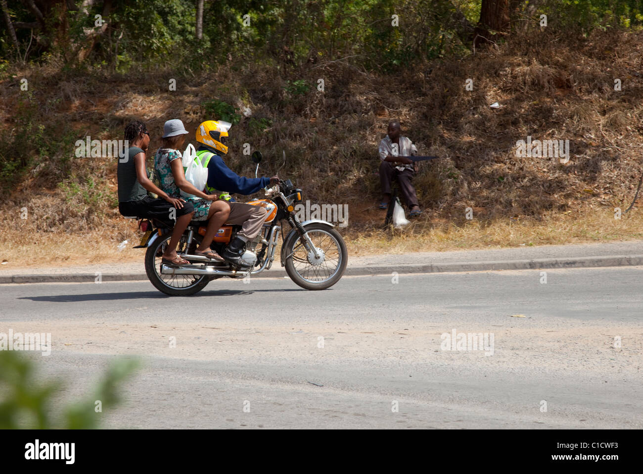 Due donne africane di passeggeri con autista sul motociclo taxi o piki piki Kilifi Kenya Foto Stock