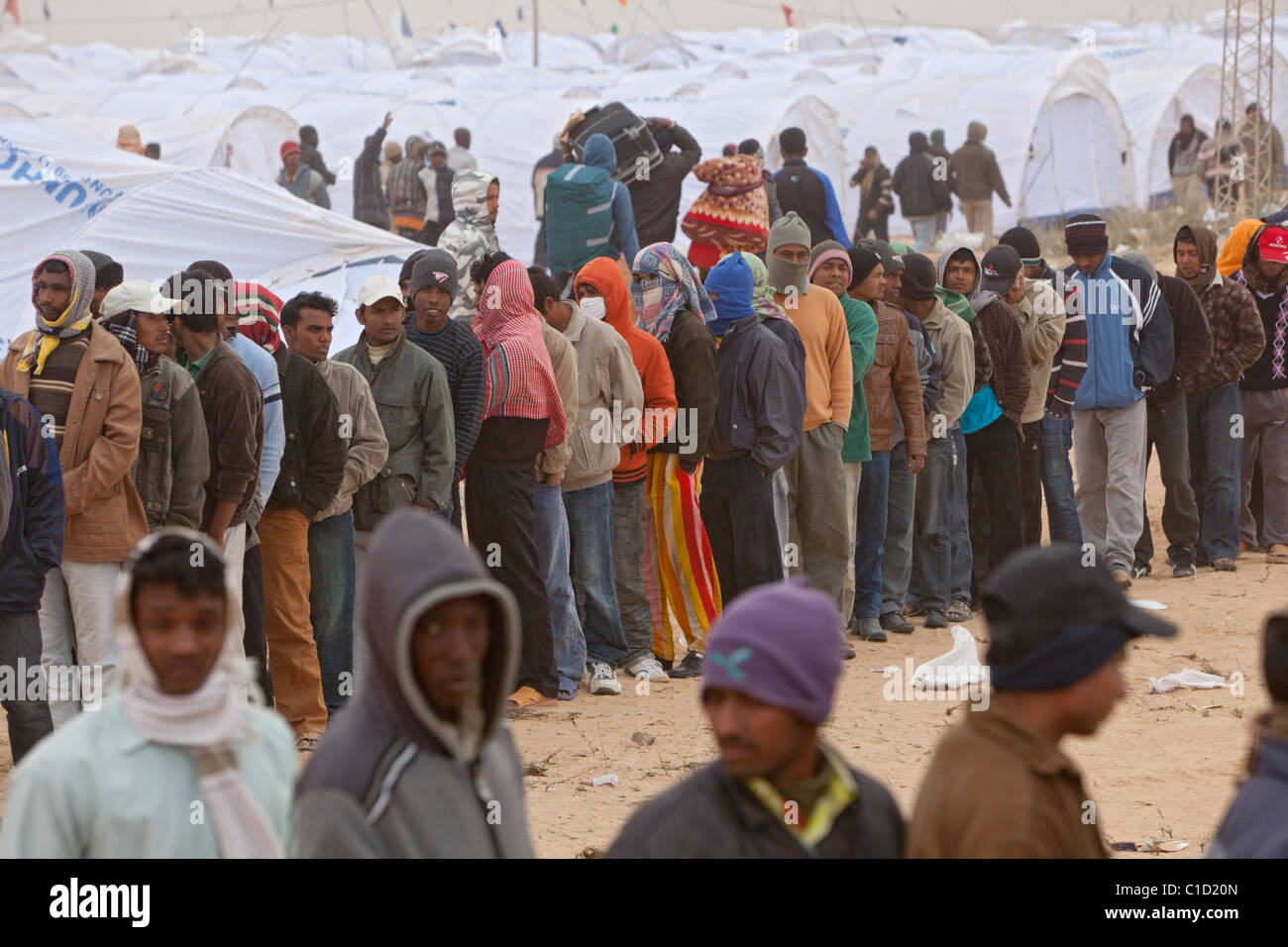 I rifugiati di Shousha Refugee Camp in attesa per la distribuzione di prodotti alimentari, Ben Gardane, Tunisia Foto Stock