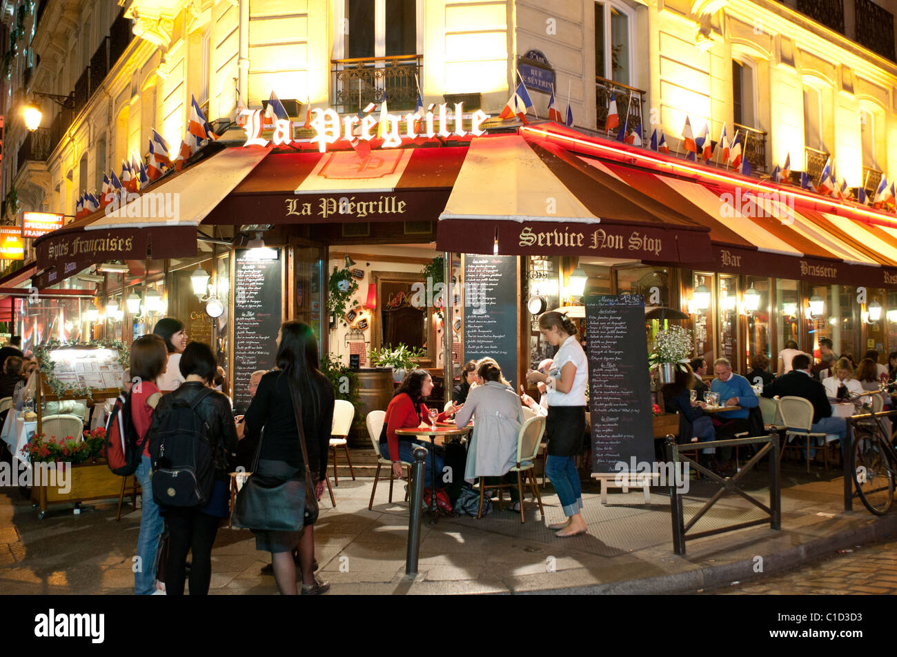 Strada parigina cafe La Pregrille di notte all' angolo di rue Saint-Severin e Rue de la Harpe nel Quartiere Latino di Parigi. Foto Stock