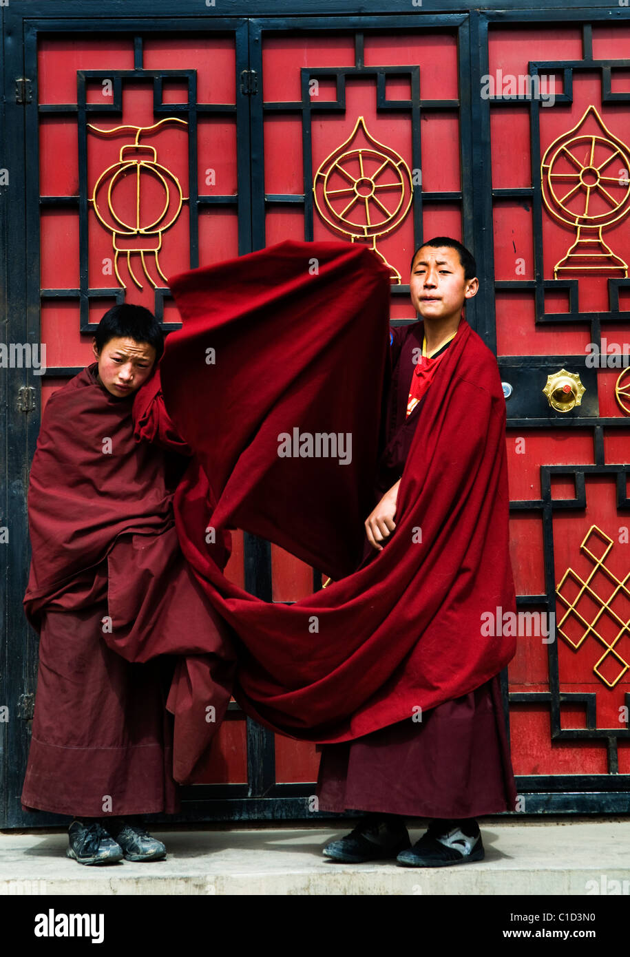 Monaci Tibetani da un colorato porta rossa. Foto Stock