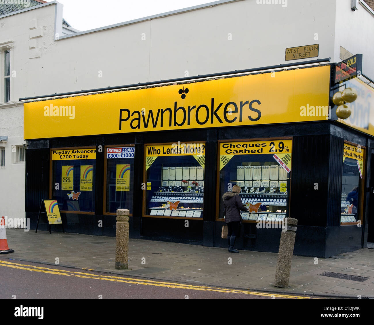 Pawnbroker negozio con donna cerca nella finestra Foto Stock