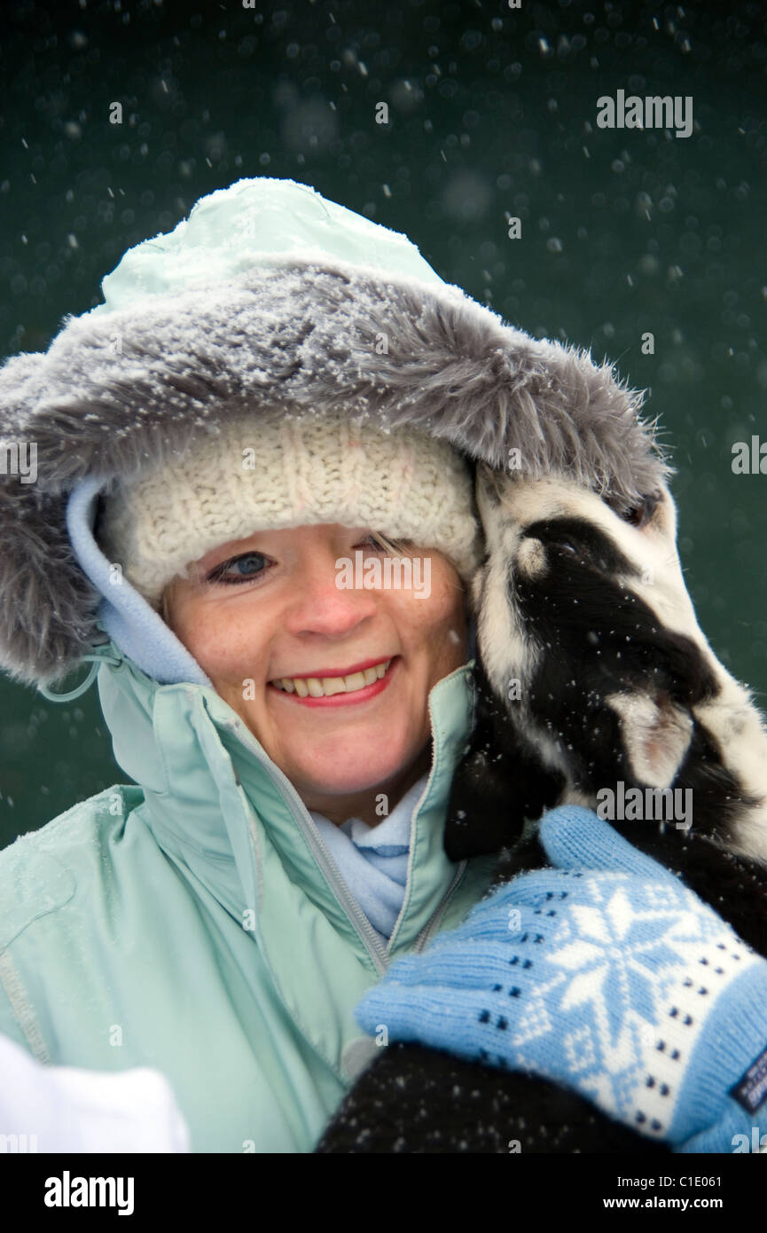 Donna che mantiene un husky cucciolo di cane in caso di neve in Churchill, Canada Foto Stock