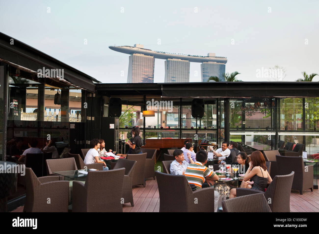 Bevande a Orgo Bar & Ristorante con Marina Bay Sands in background. Il Marina Bay, Singapore Foto Stock