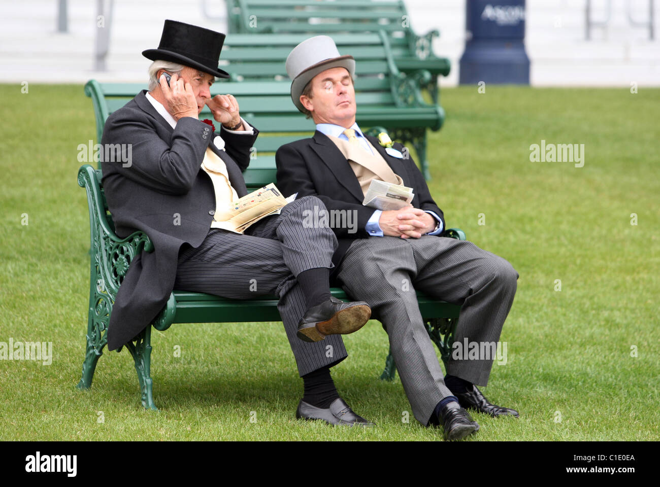 Elegantemente vestito uomini seduti su una panchina, Ascot, Regno Unito Foto Stock