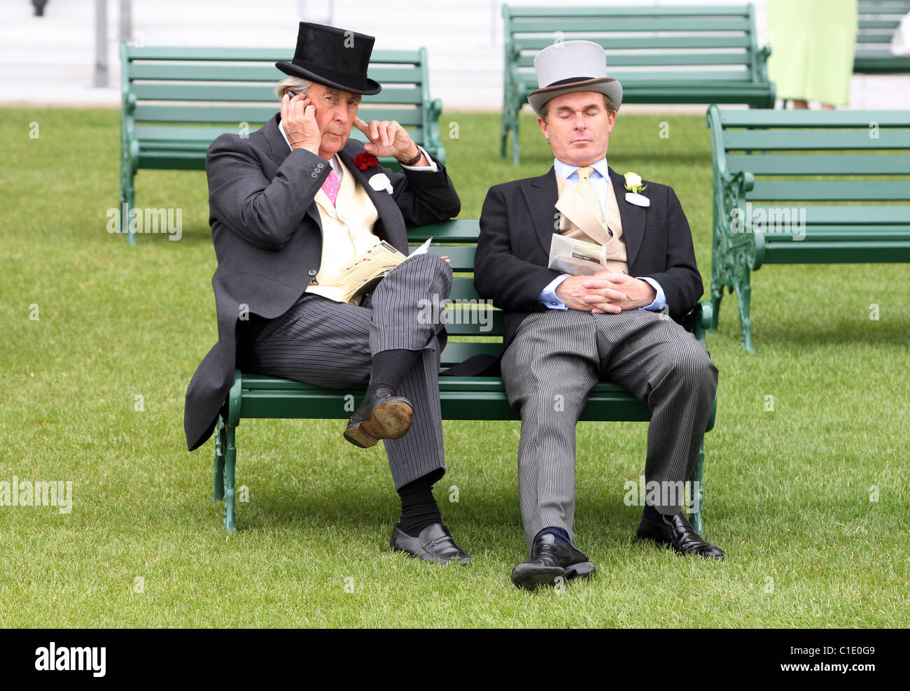 Elegantemente vestito uomini seduti su una panchina, Ascot, Regno Unito Foto Stock