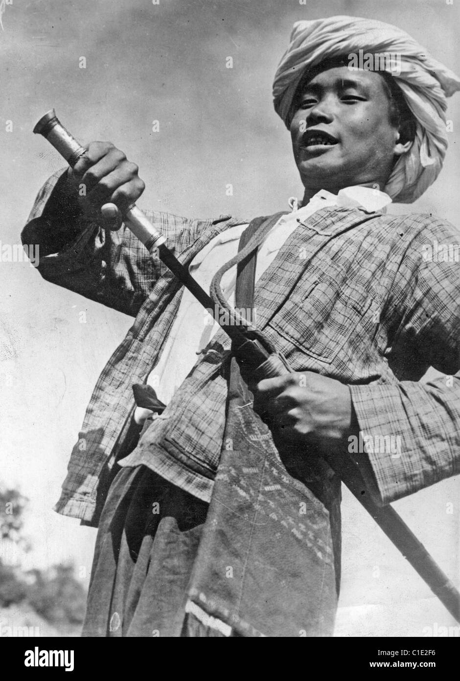 La Birmania 1940 membro della tribù Kachin lotta contro l'invasione giapponese. La sua spada è chiamato un Dah. Foto Stock