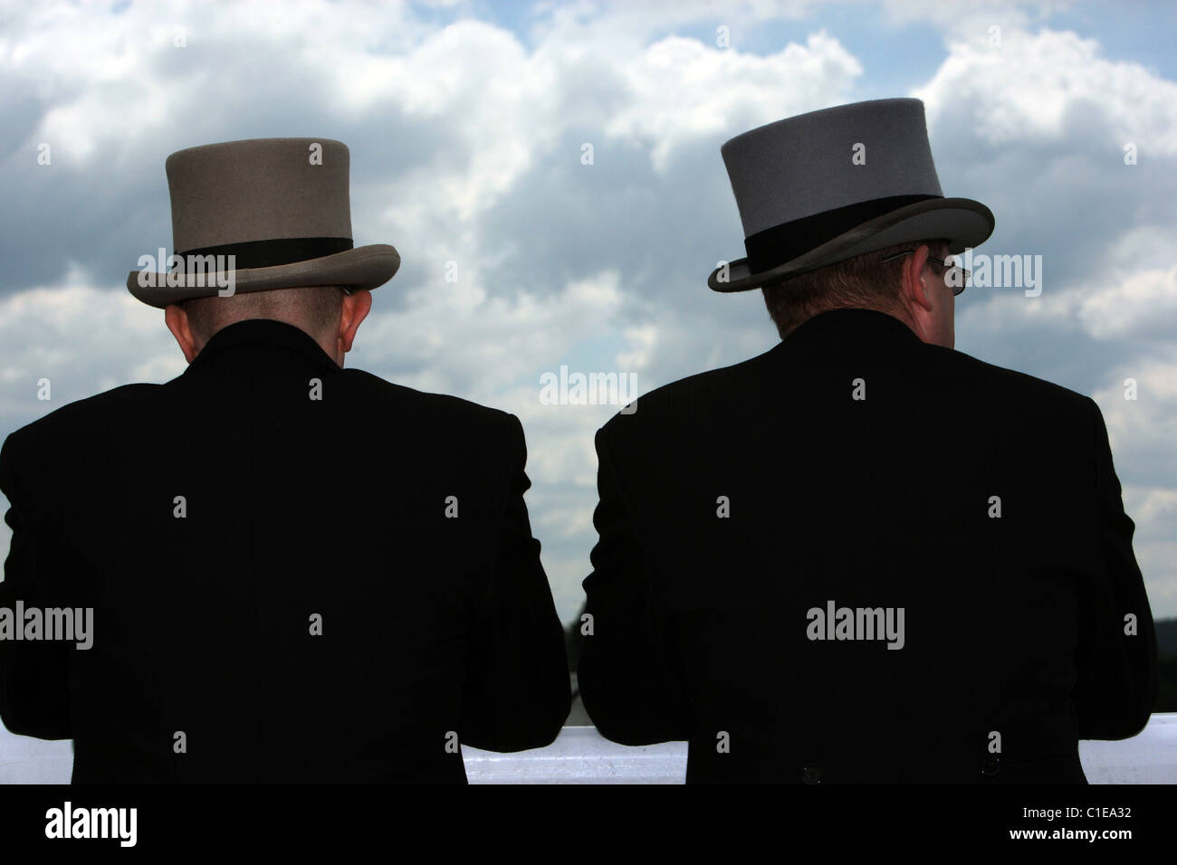 Gli uomini in cappelli superiore nella parte anteriore del cielo nuvoloso, Epsom, Regno Unito Foto Stock