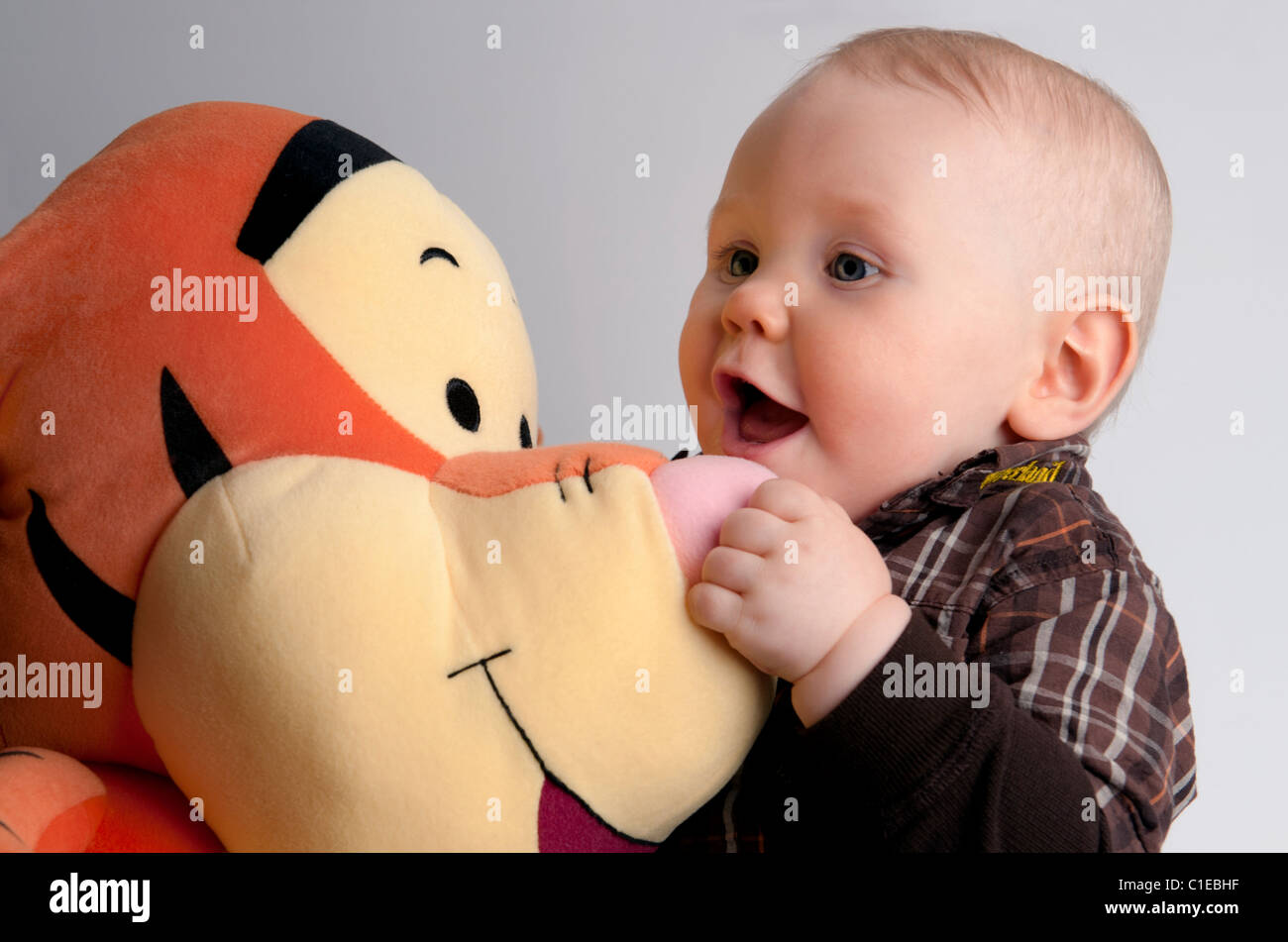 Nove mesi di età baby boy con un Disney giocattolo plushie. Foto Stock