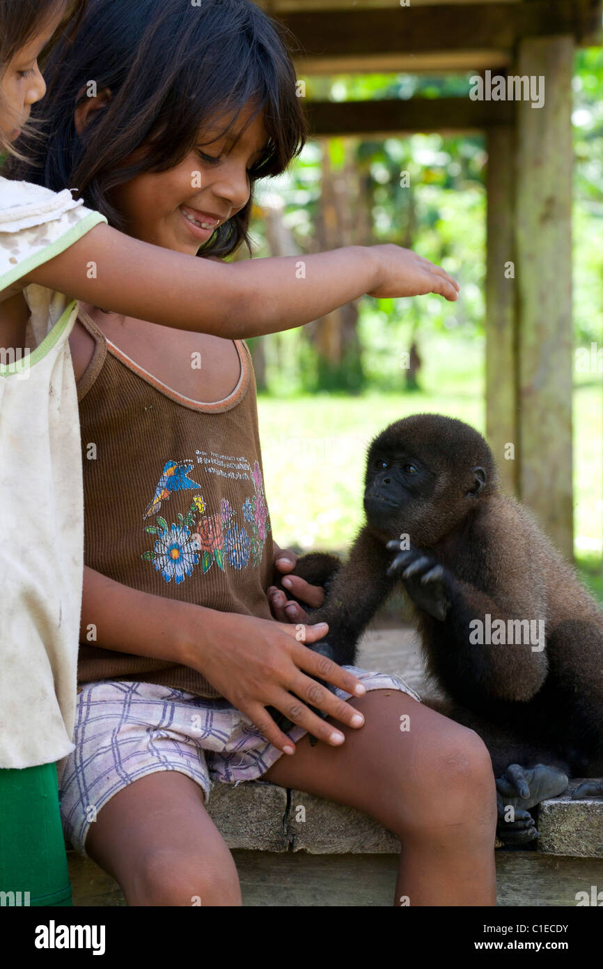 Siona persone village, profonda nel ecuadoriano giungla amazzonica (cuyabeno wildlife riserva). I locali di interagire con scimmietta Foto Stock