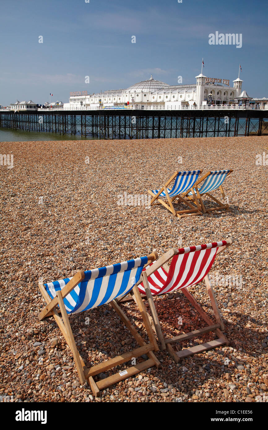 Sedie a sdraio e il Brighton Pier ( Brighton Palazzo Marino e il molo - 1899 ), Brighton East Sussex, England, Regno Unito Foto Stock