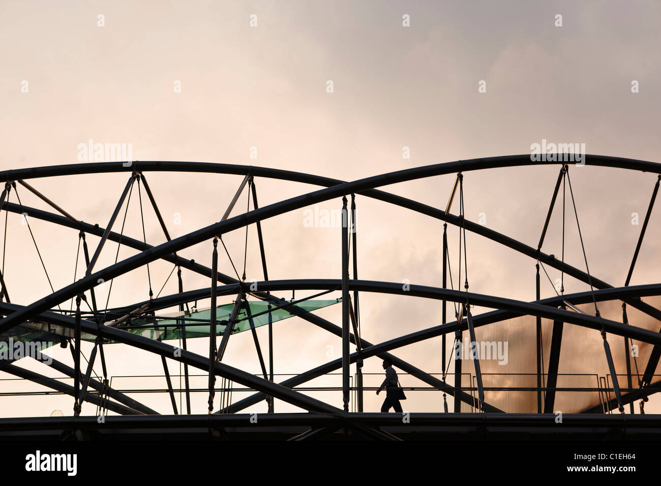 Uomo che cammina attraverso il ponte di Elica. Il ponte collega il Marina Bay Sands Hotel di Marina Centro. Il Marina Bay, Singapore Foto Stock