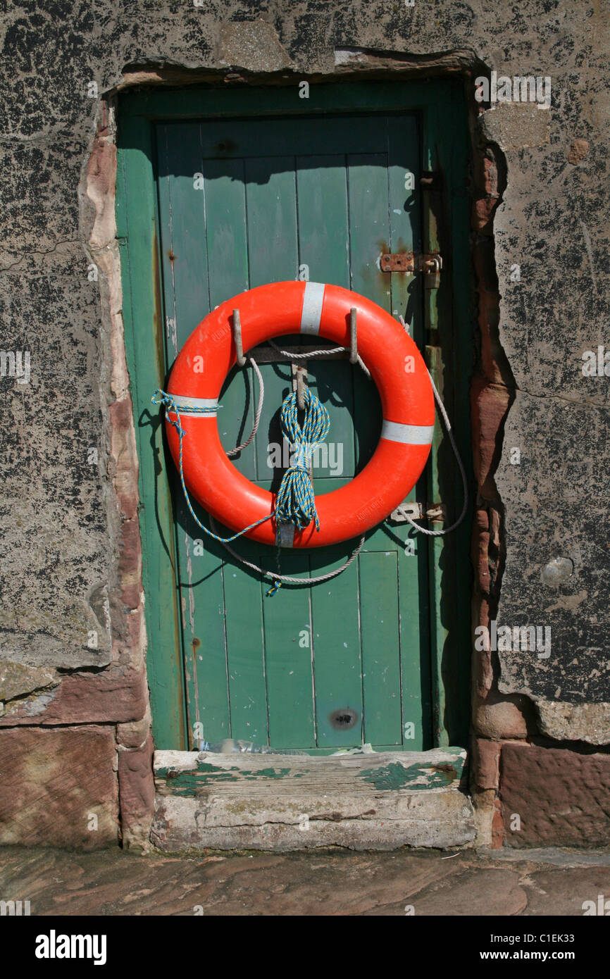 Salvagente appeso sulla porta della ex Stazione di salvataggio su Hilbre Island, il Wirral, Merseyside, Regno Unito Foto Stock