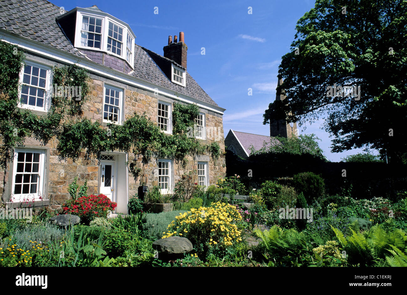 Regno Unito, Isole del Canale e Isola di Guernsey, casa circondata da fiori accanto a San Martin de la Bellouse Foto Stock