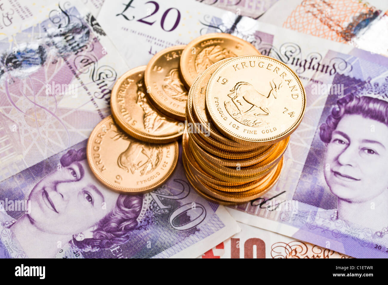 Una pila di krugerrand sulla sterlina note Foto Stock