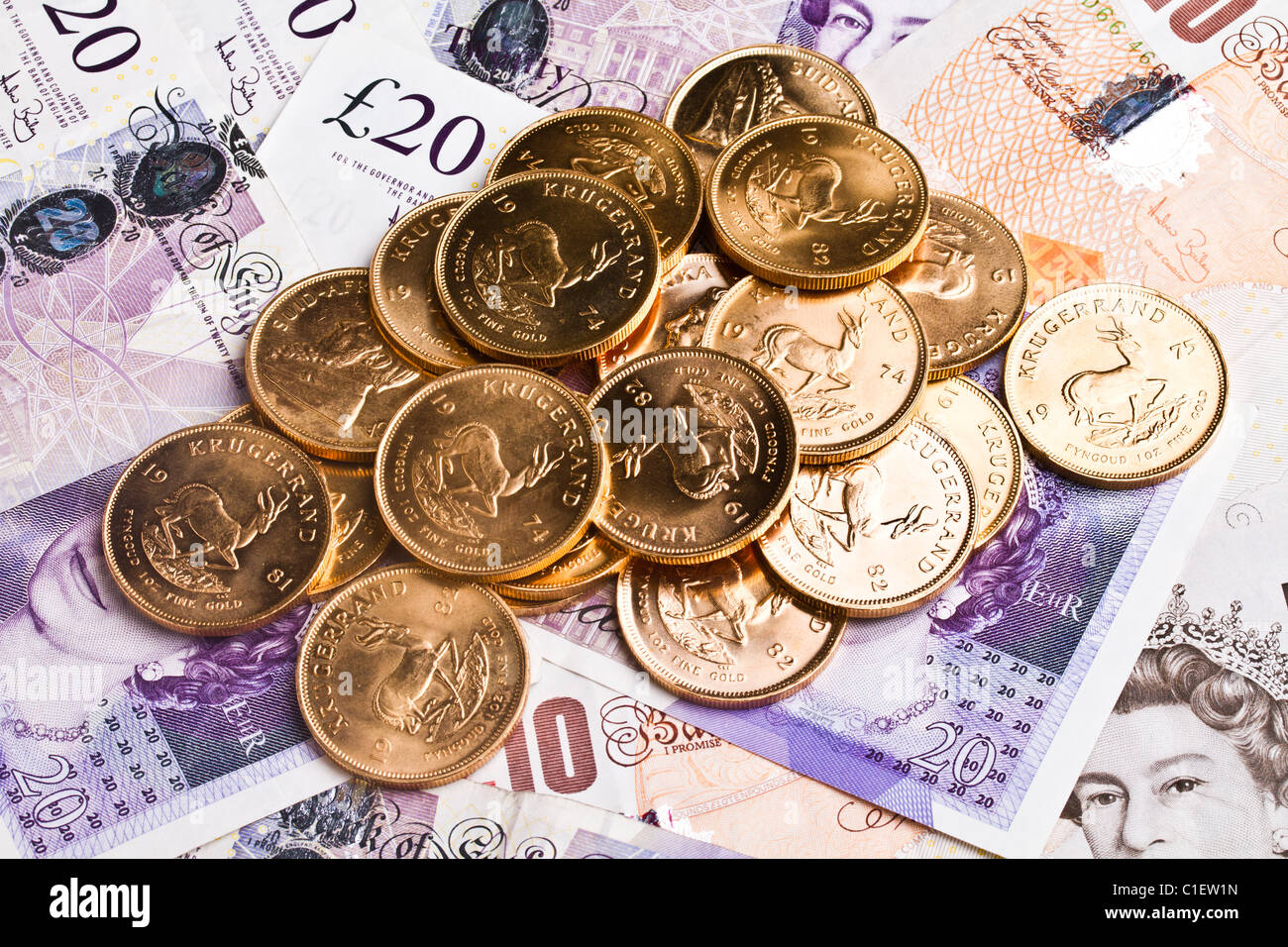 Un mucchio di krugerrand sulla sterlina note Foto Stock