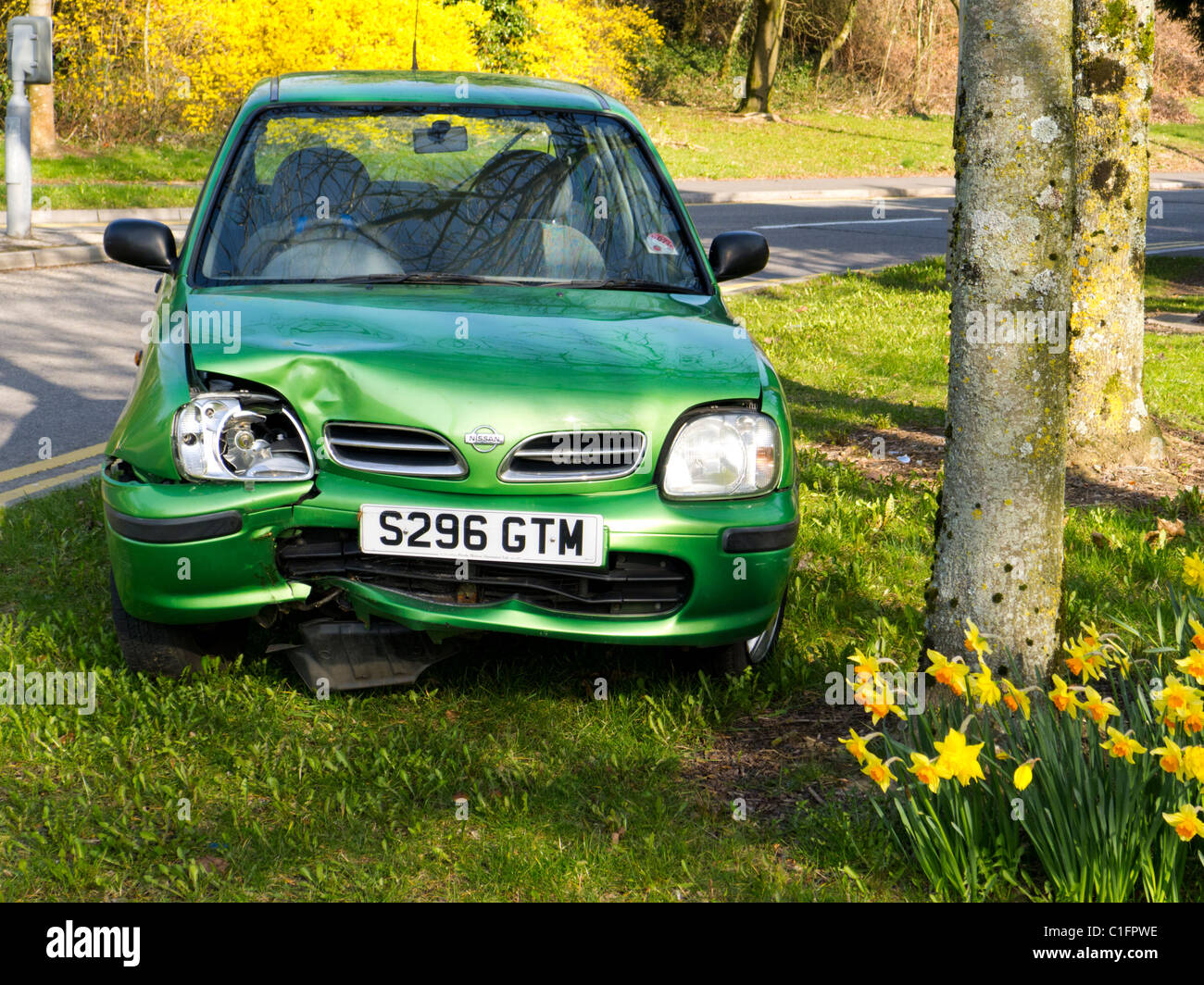 Piccolo verde Nissan Micra auto dopo scontro frontale in albero sul paese rurale road Foto Stock