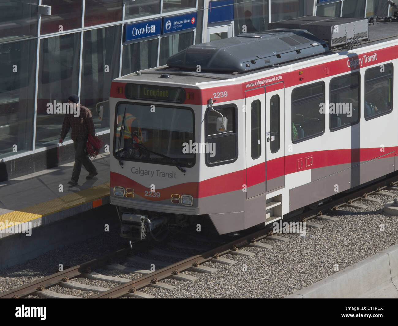 Uomo che cammina fuori Calgary C-treno all'Crowfoot stazione LRT in NW Calgary Alberta Canada Foto Stock