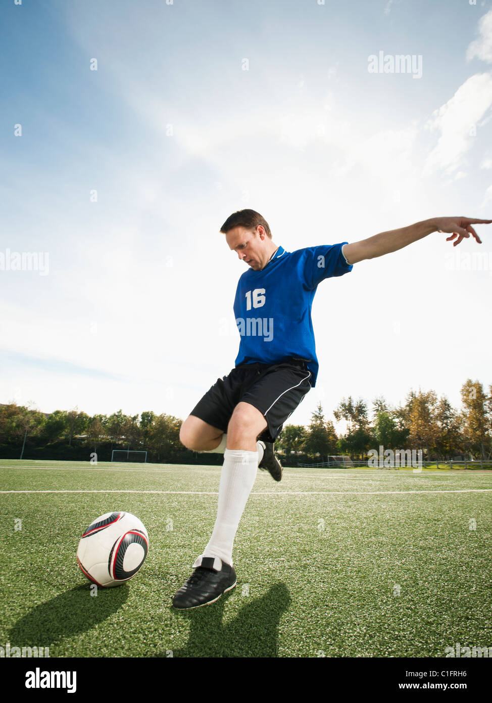 Caucasian giocatore di calcio calci palla calcio Foto Stock