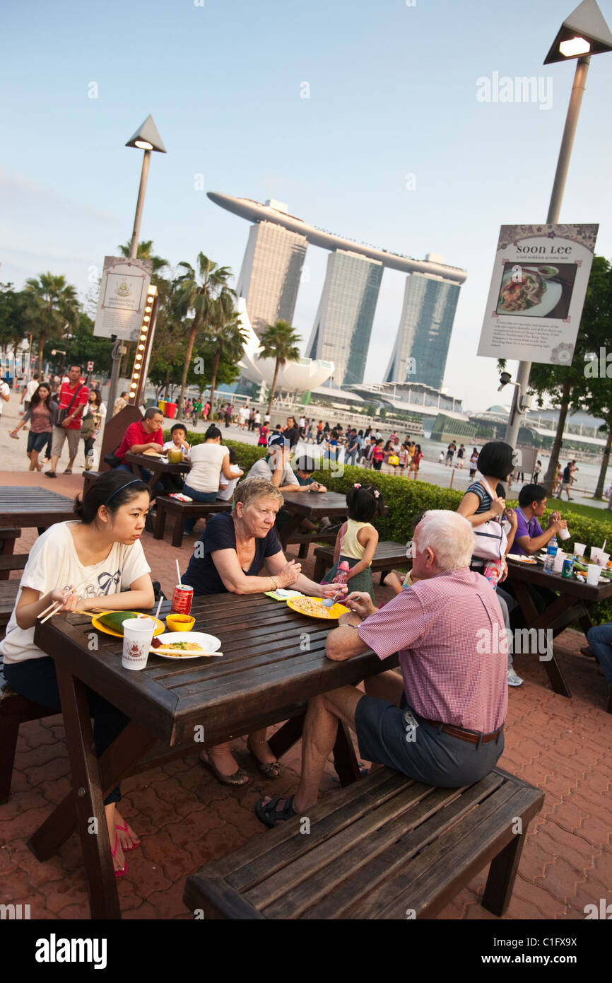 Diners a Makansutra golosi Bay food court con il Marina Bay Sands in background. Il Marina Bay, Singapore Foto Stock