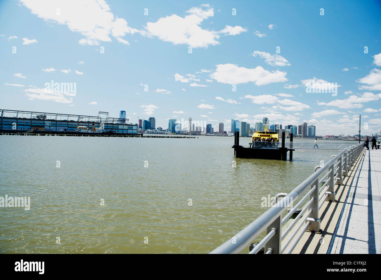 Skyline di New York sotto il cielo blu con un New York giallo taxi d'acqua. Foto Stock