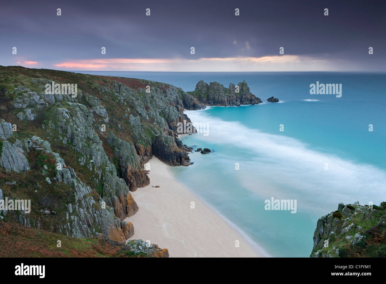 Spiaggia Pednvounder e Logan Rock da Treen Cliff, Porthcurno, Cornwall, Inghilterra. In autunno (ottobre 2010). Foto Stock