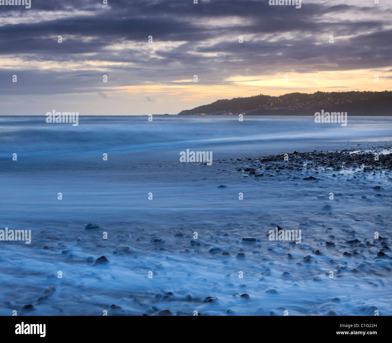 Ocean spazzato rive di Charmouth spiaggia al crepuscolo, guardando verso Lyme Regis, Jurassic Coast, Dorset, Inghilterra. Foto Stock