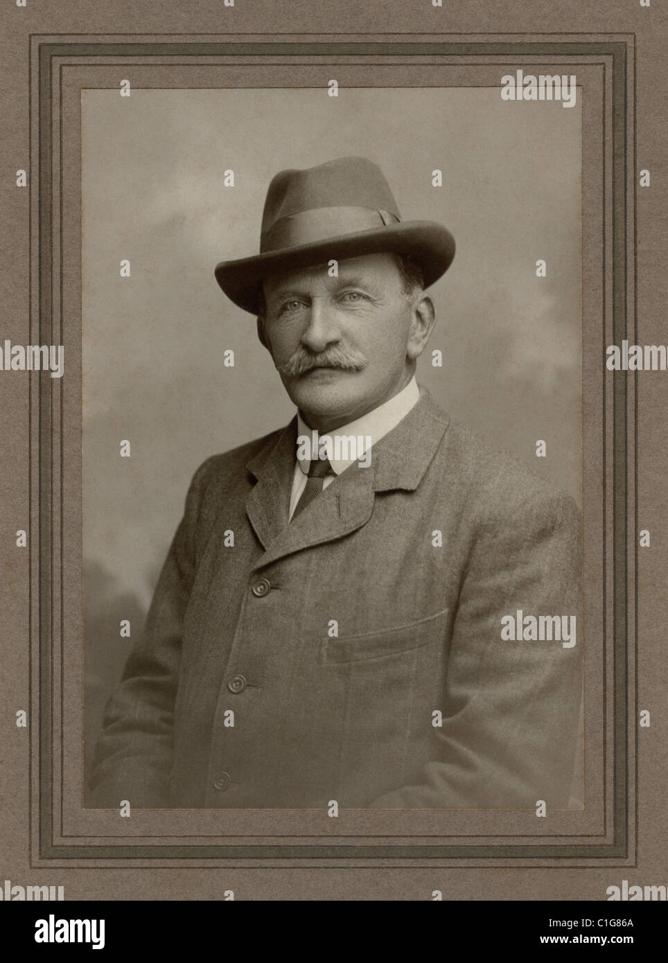 Originale e molto nitido ritratto in studio dell'epoca della prima Guerra Mondiale di un uomo maturo vestito in modo intelligente, rivolto verso la fotocamera con sicurezza, un gentiluomo alla moda che indossava un cappello Homburg, un costume in tweed, un collare e una cravatta, la moda per i collari divenne più stretta durante la prima guerra mondiale - datato 2 giugno 1917 sul retro, Bexhill-on-Sea, vicino a Hastings e Eastbourne, Sussex, Regno Unito Foto Stock