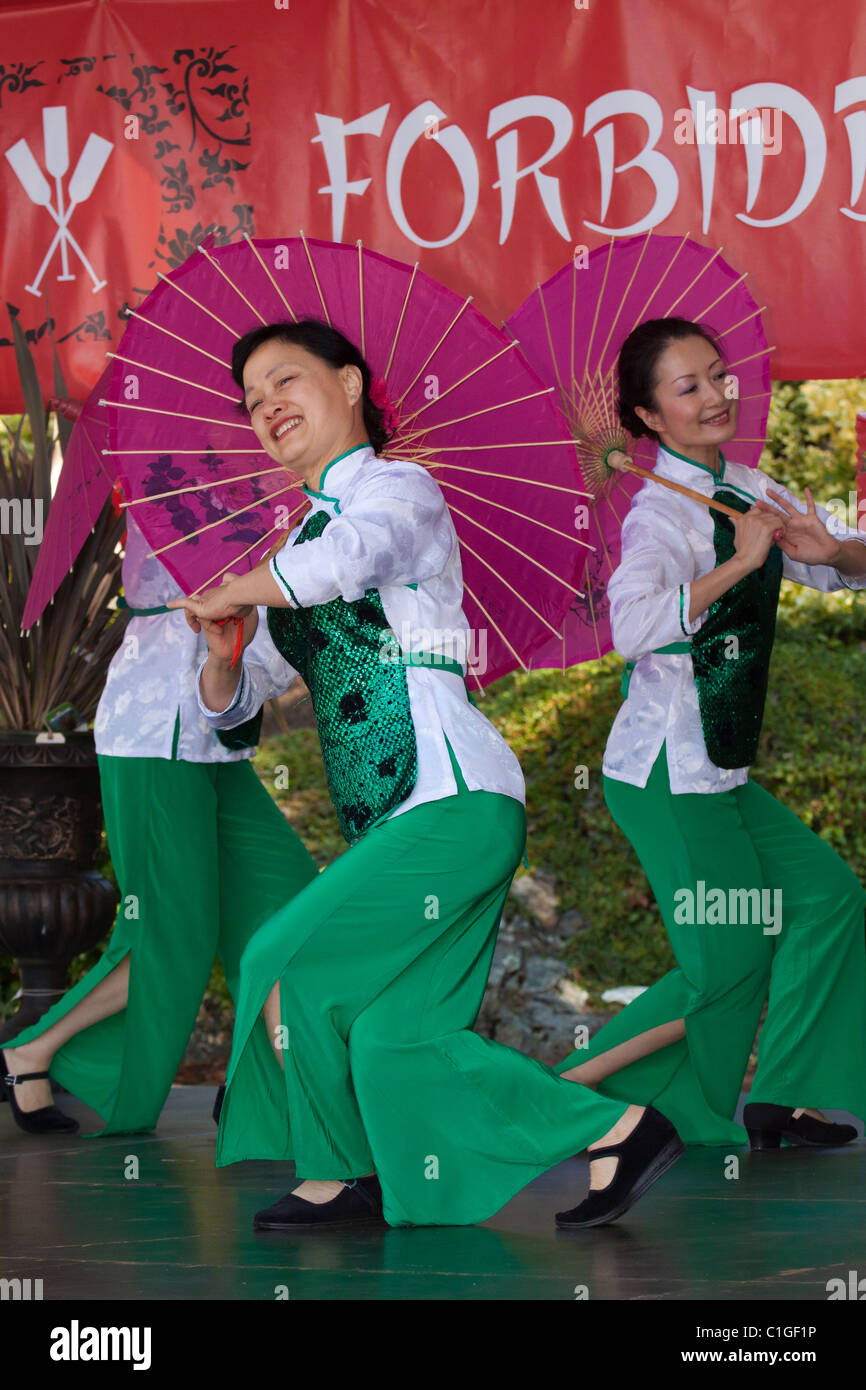 Ocean pioggia femminile cinese esecutori di danza dancing in Dragon Boat Festival-Victoria, British Columbia, Canada. Foto Stock