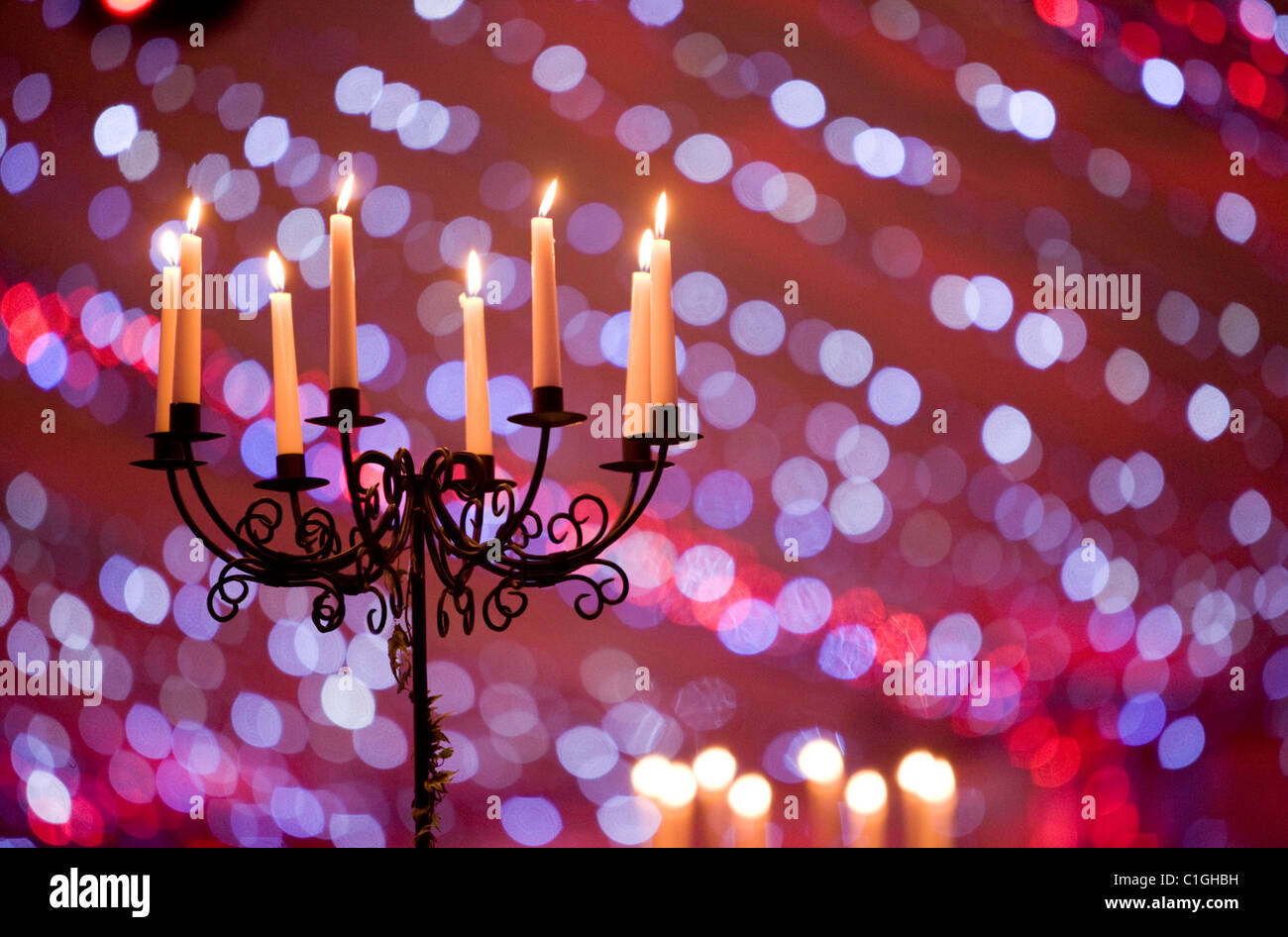 Le candele accese sul pavimento candelabri in camera grande con morbide palline di colorata colorata blu e luce rosa Foto Stock