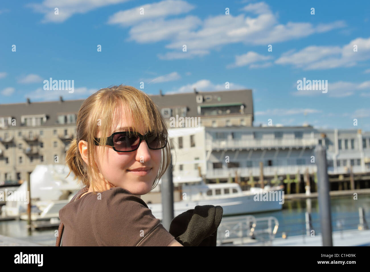 Bella bionda Teen Girl Età 17 sorridente indossando occhiali da sole al Porto di Boston al Porto di Boston Boston, Massachusetts, USA. Modello rilasciato Foto Stock