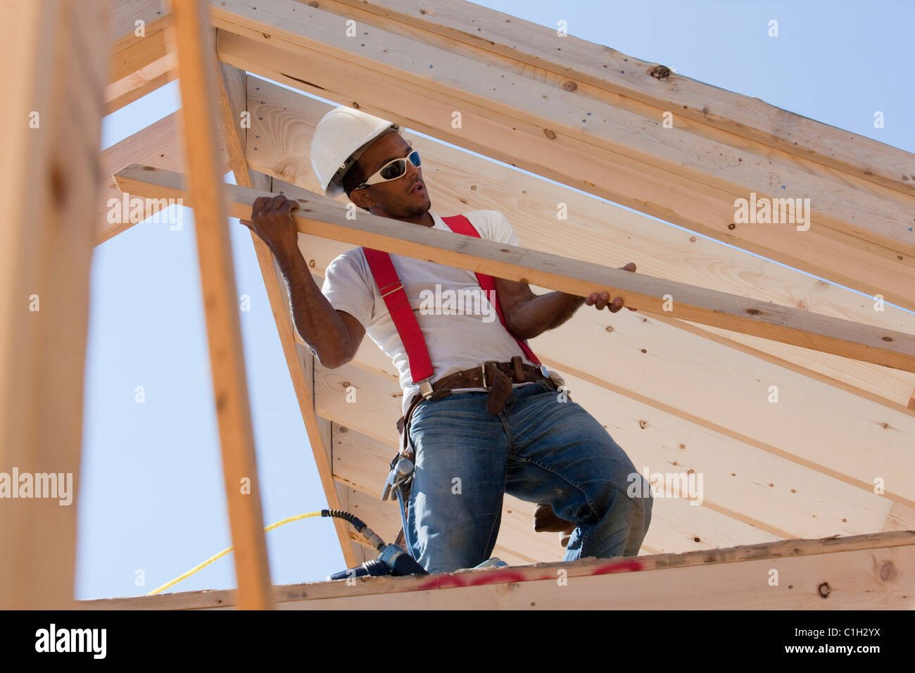 Carpenter portante un puntone del tetto Foto Stock