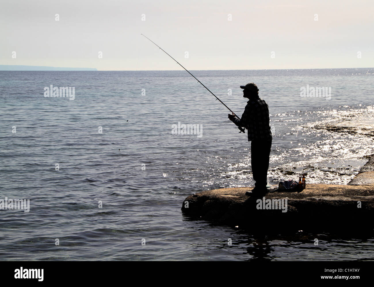 Silhouette di uomo la pesca in mare in Maiorca. Foto Stock