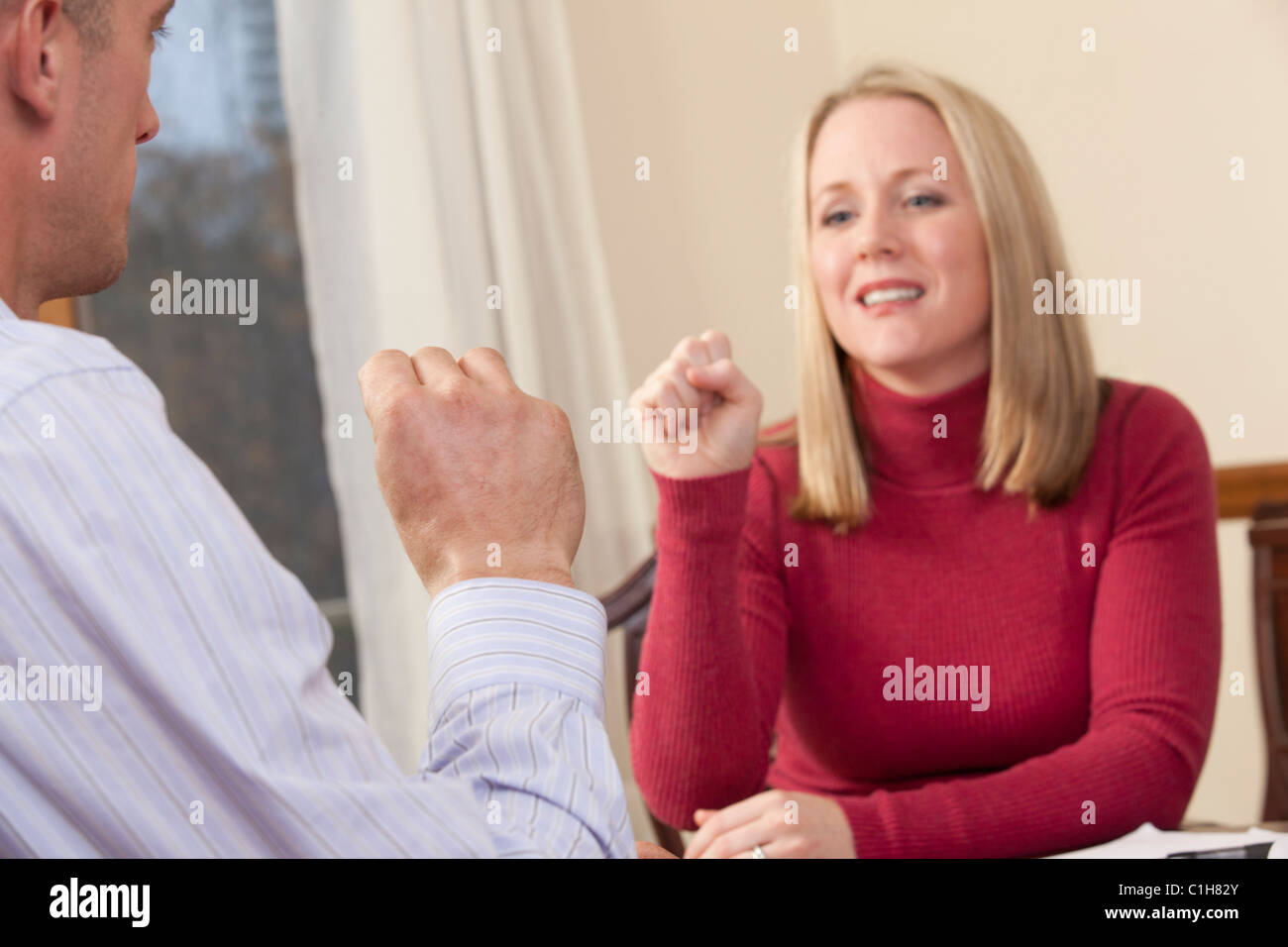 Donna firma la parola " sì " in American Sign Language durante la comunicazione con un uomo Foto Stock