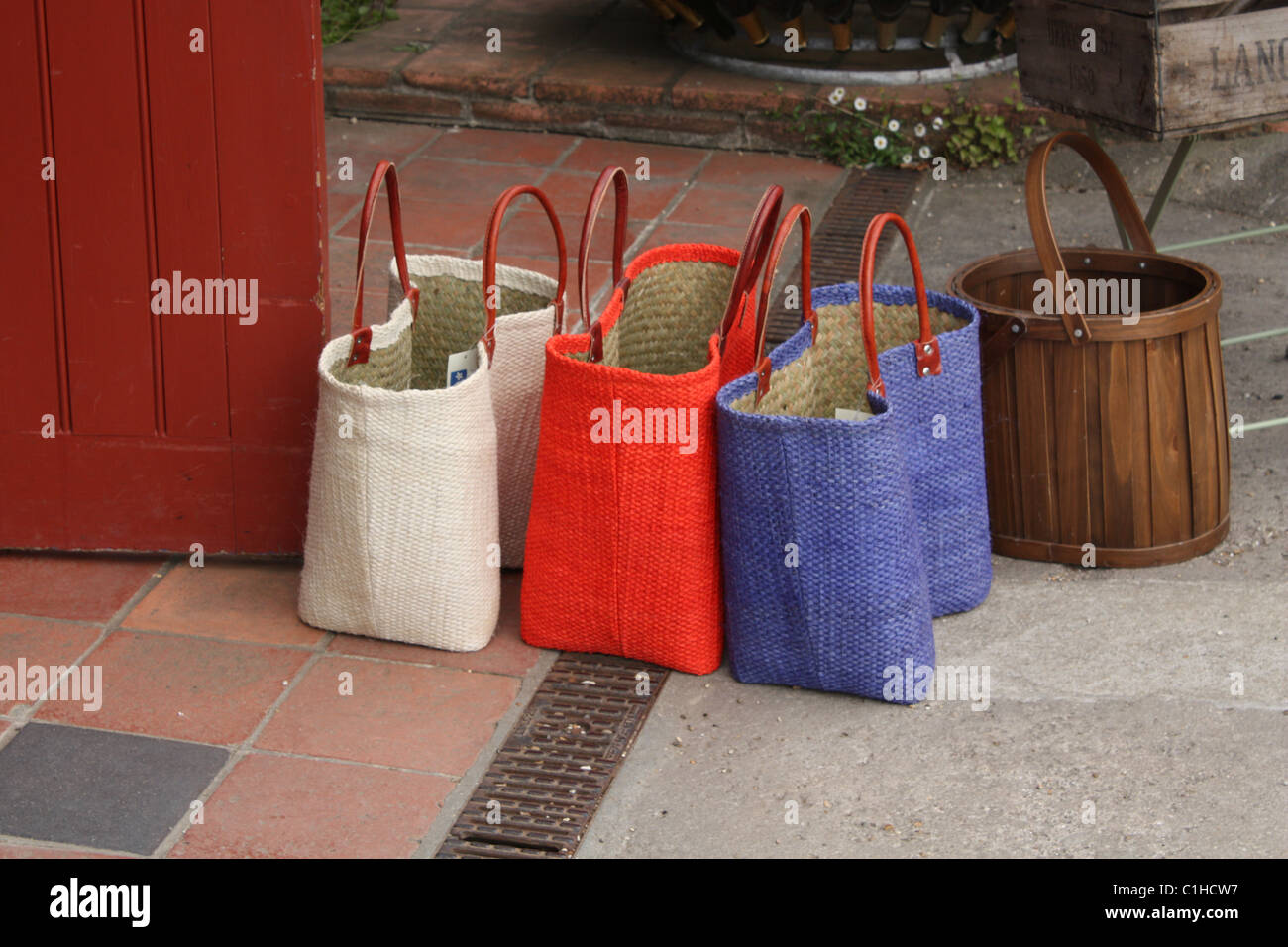 Rosso Bianco e blu borse per lo shopping in un negozio porta Foto Stock